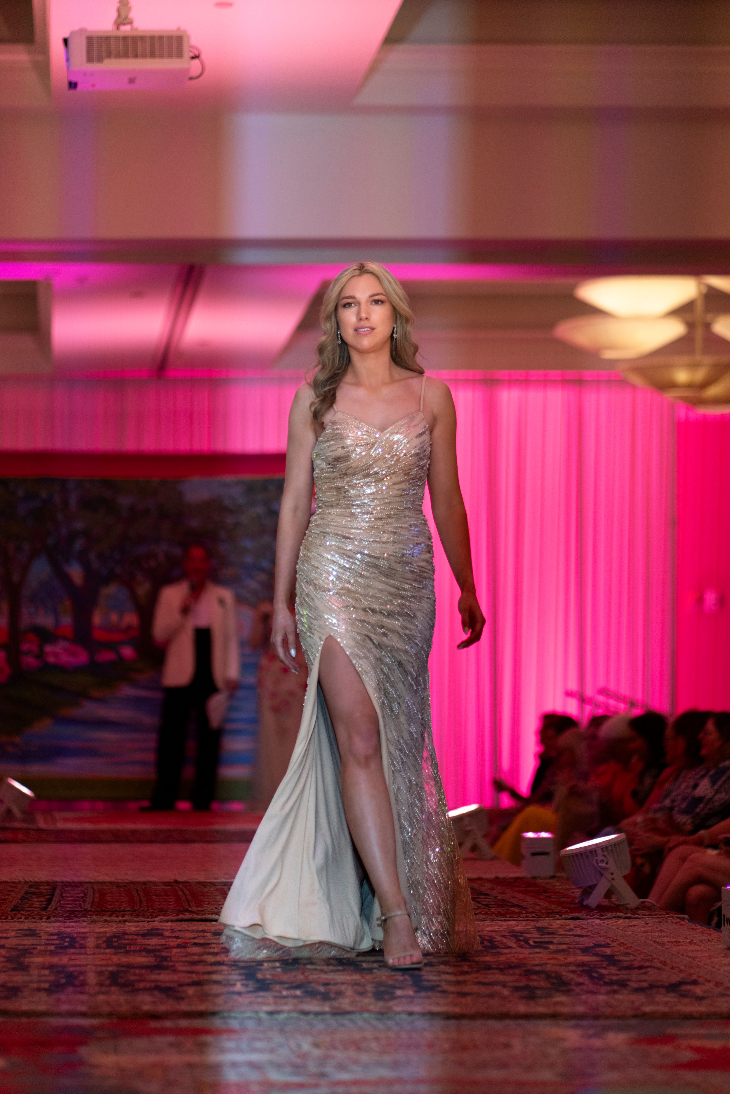 A guest in a sparkling silver evening gown walks down during the Azalea festival spring fashion show runway 2026