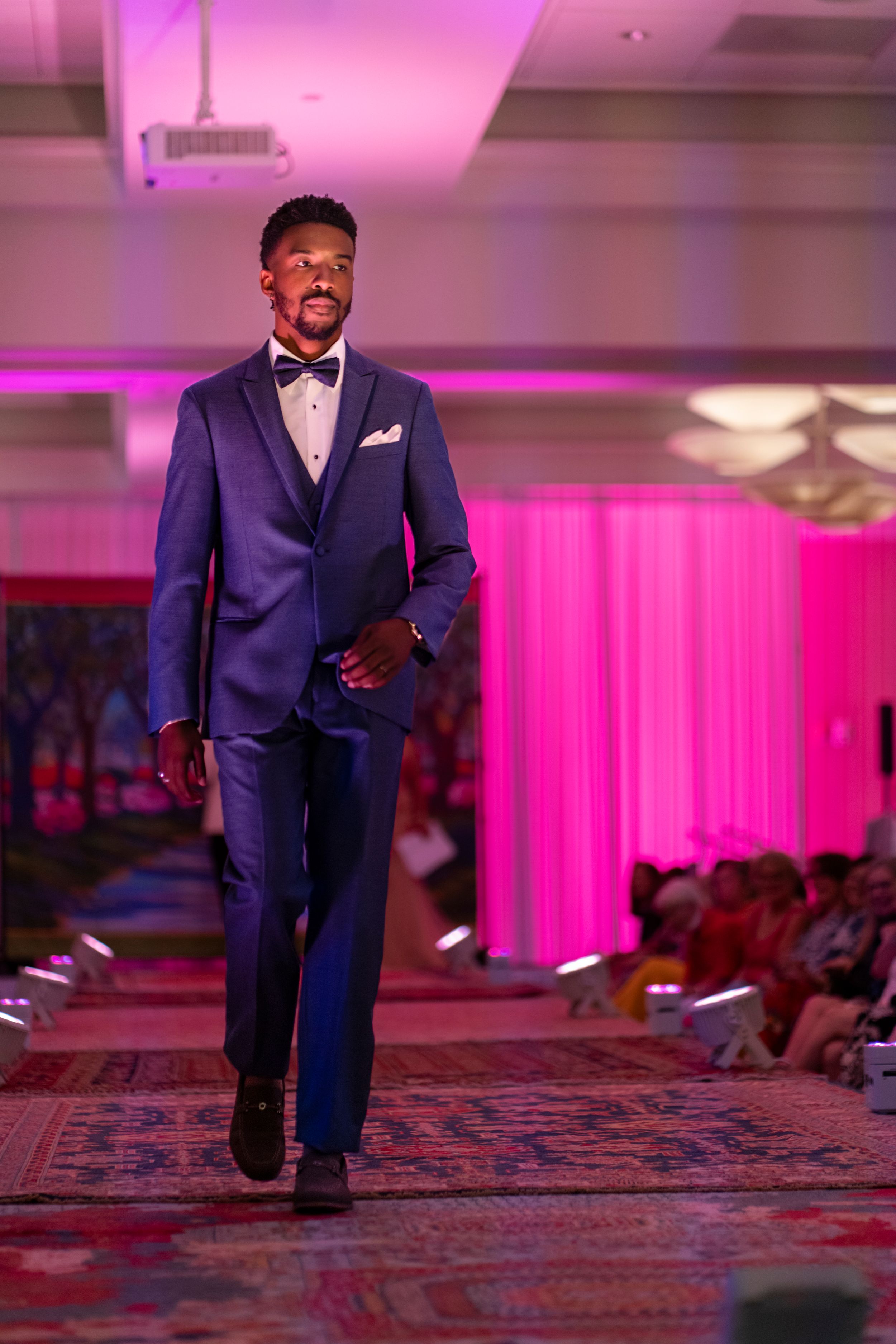 Cj Grae walk forGentlemen’s Corner down the runway in a navy blue suit during the Azalea Festival Spring Fashion Show runway 2026