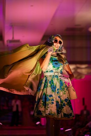 A model twirls in a floral print dress on the runway during the Azalea spring fashion show 2026 located at wrightsville beach holiday inn