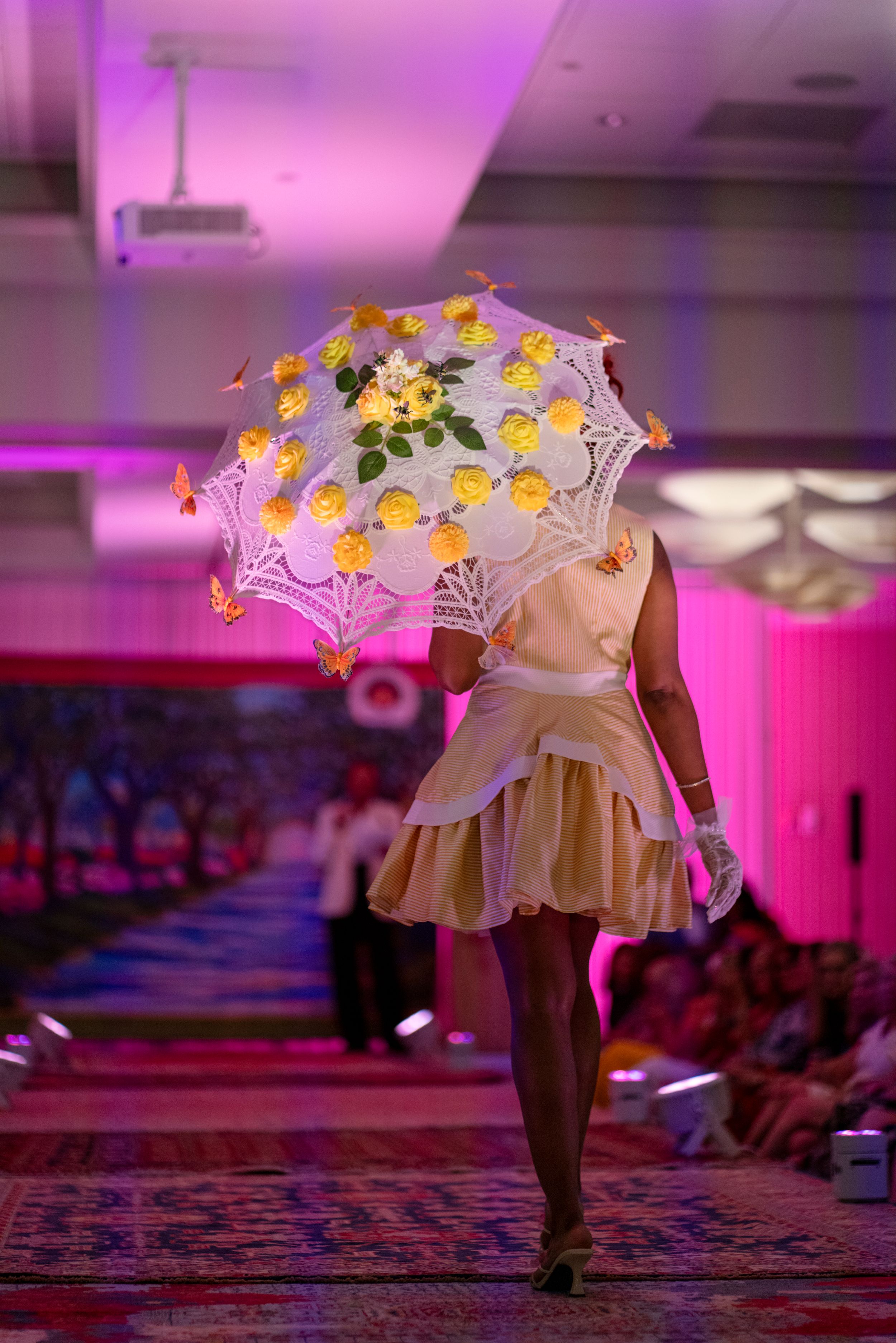 Lead model Lanatria, Caribbean Cowgirl, 2026 Azalea Festival Spring Fashion Show runway,parasol created by Chris Gore, Holiday Inn Resort