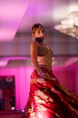 A close up look of the guest in her red and gold beaded traditional Indian sari during the azalea spring fashion show runway 2026