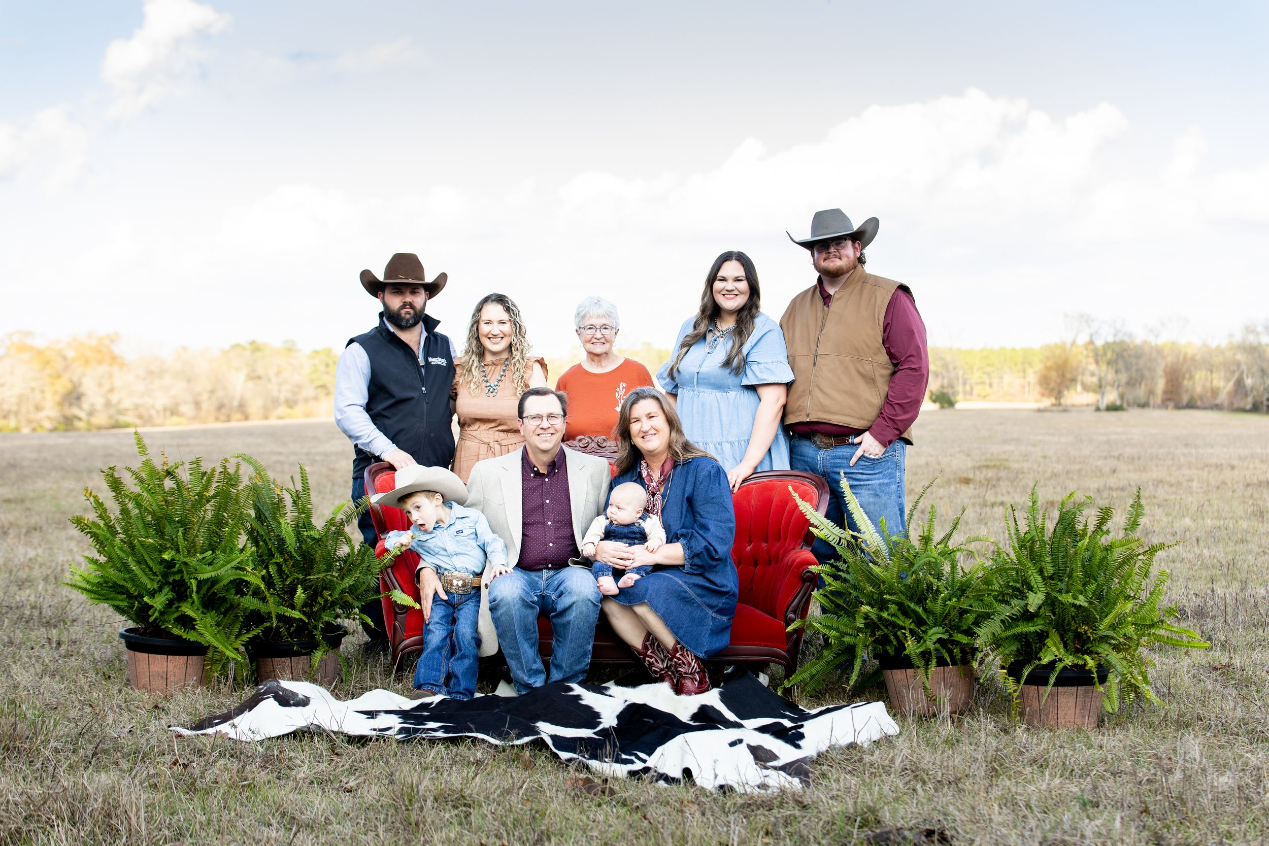 Family group relaxing on blankets outdoors in rural setting during golden hour.