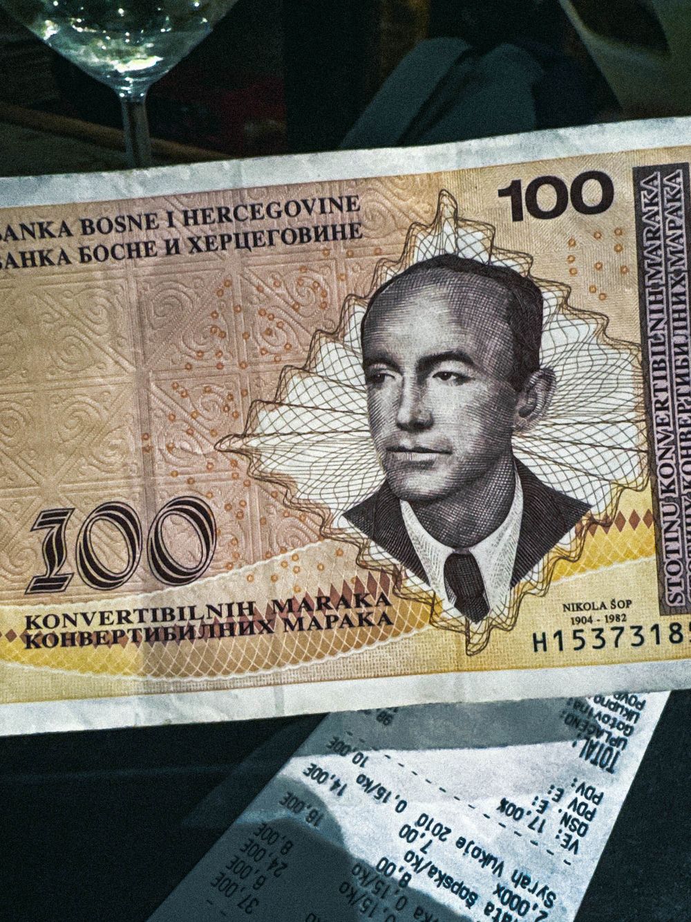 100 Bosnian Convertible Marka banknote featuring portrait of Nikola Šop on golden currency bill.