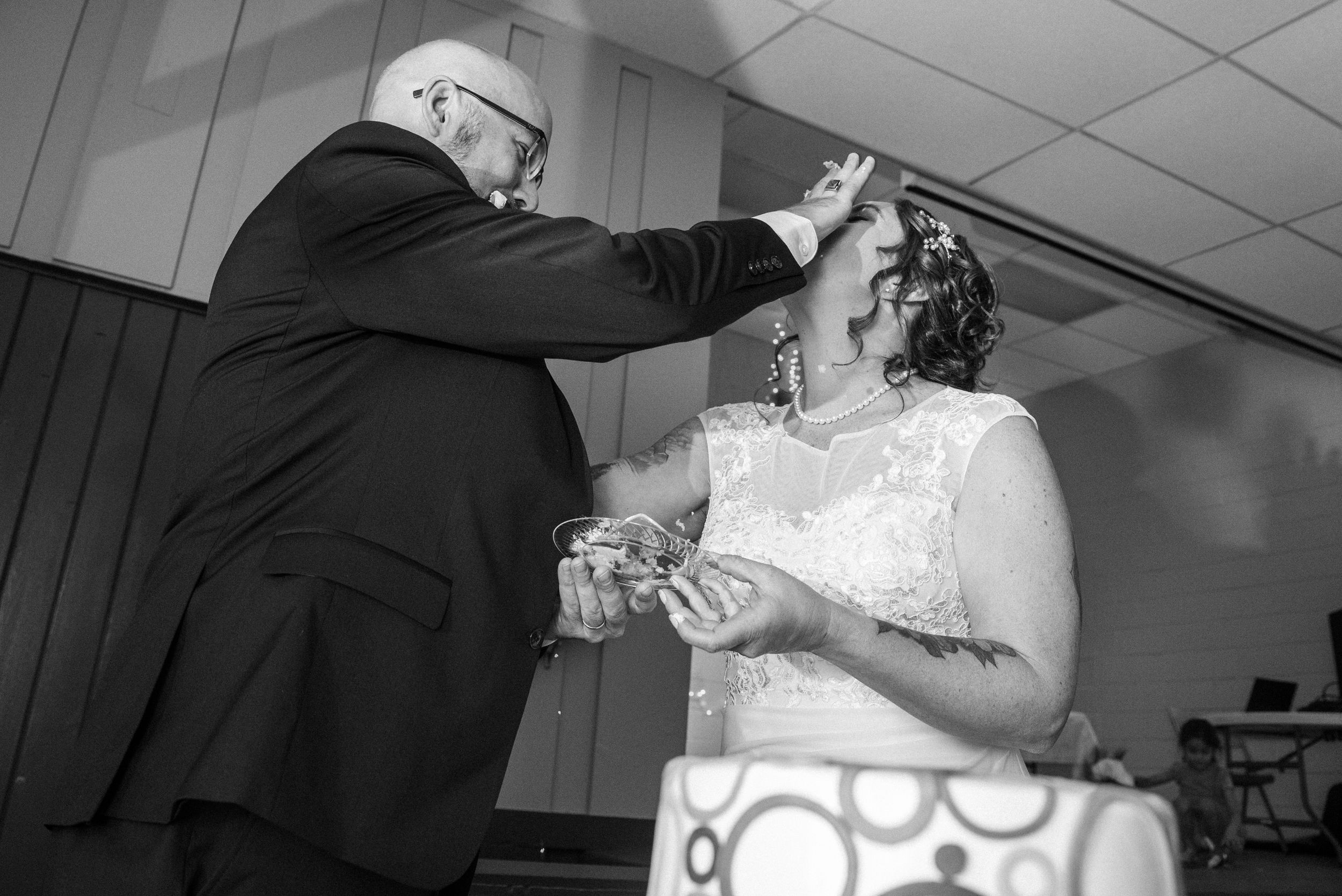 A bride and groom share a tender dance moment at their wedding reception on a dance floor.