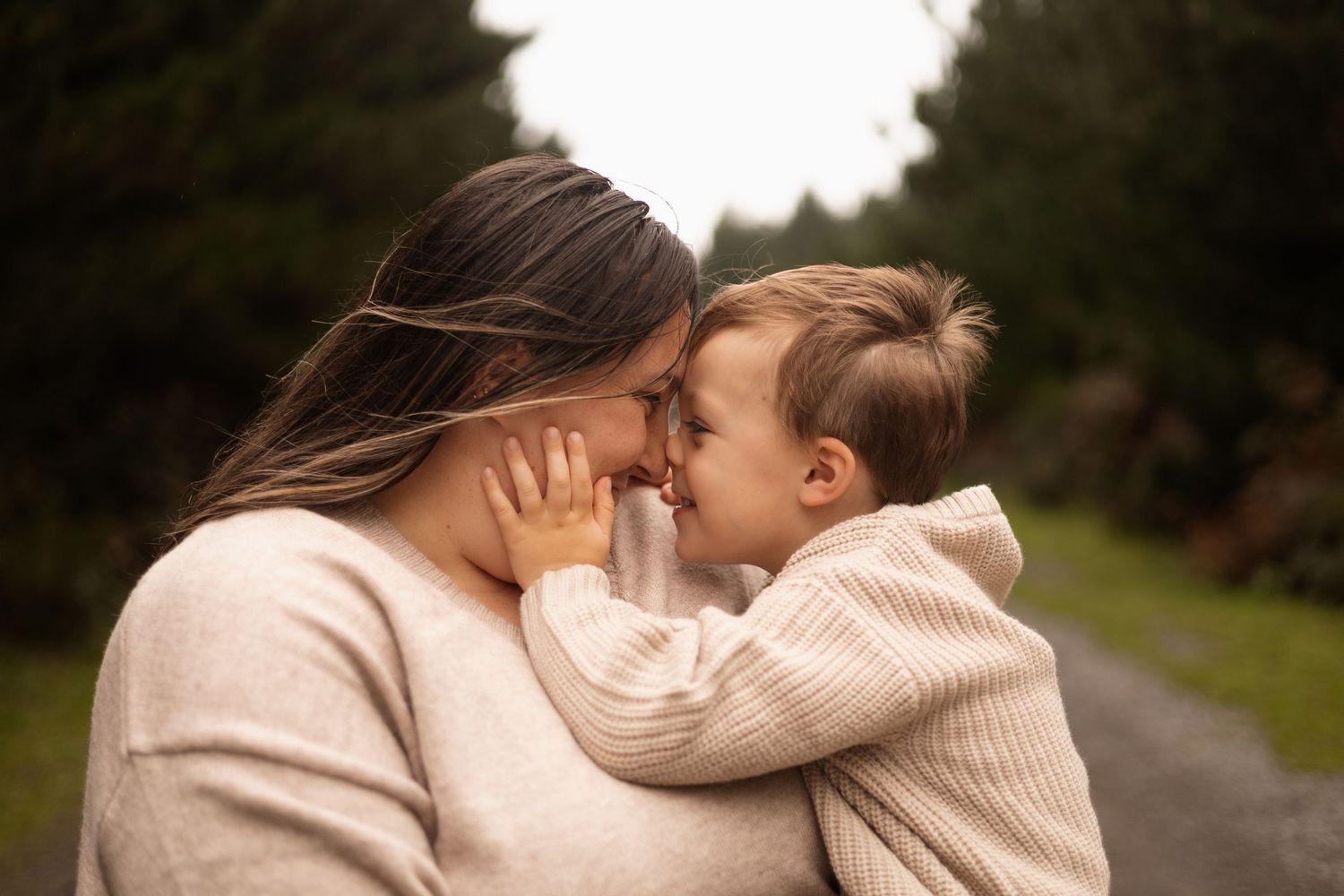 Mother and son cuddling in during family session at Bottle lake forest, christchurch
