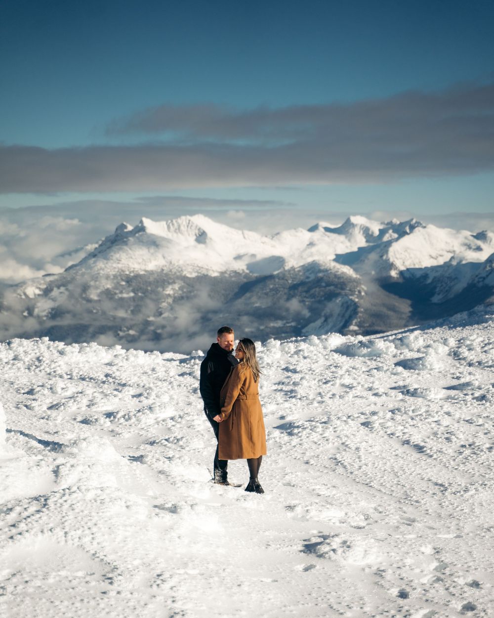 Couple embracing on snowy mountain peak with stunning alpine panorama behind them.

Vancouver Canada Scene