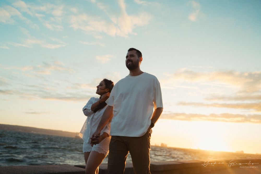 Couple standing together at sunset by the ocean, man in white tee, woman in white dress, golden sky.

Vancouver Canada Scene
