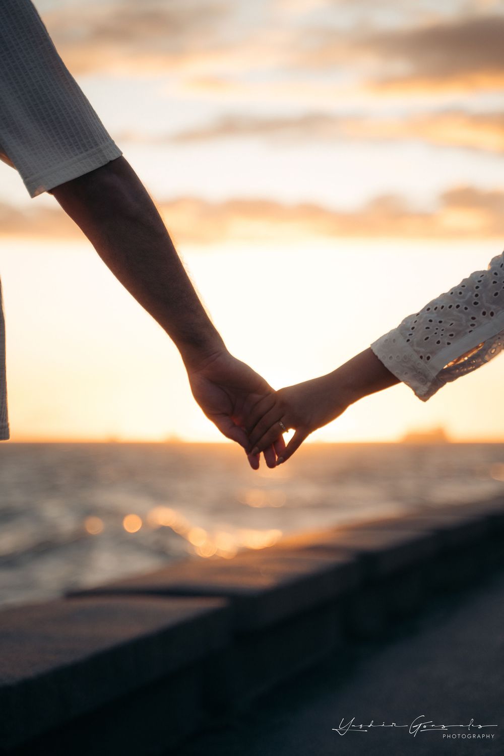 Couple holding hands at sunset by the ocean, silhouetted against golden sky.

Vancouver Canada Scene