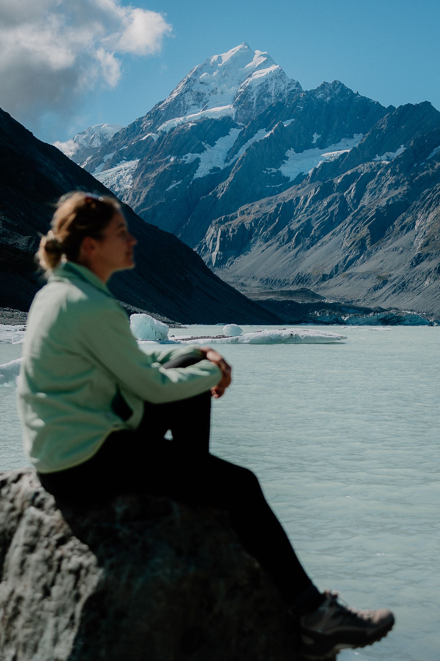 A scenic view of Mount Cook in New Zealand with a frozen lake and snow-capped peaks in the background.