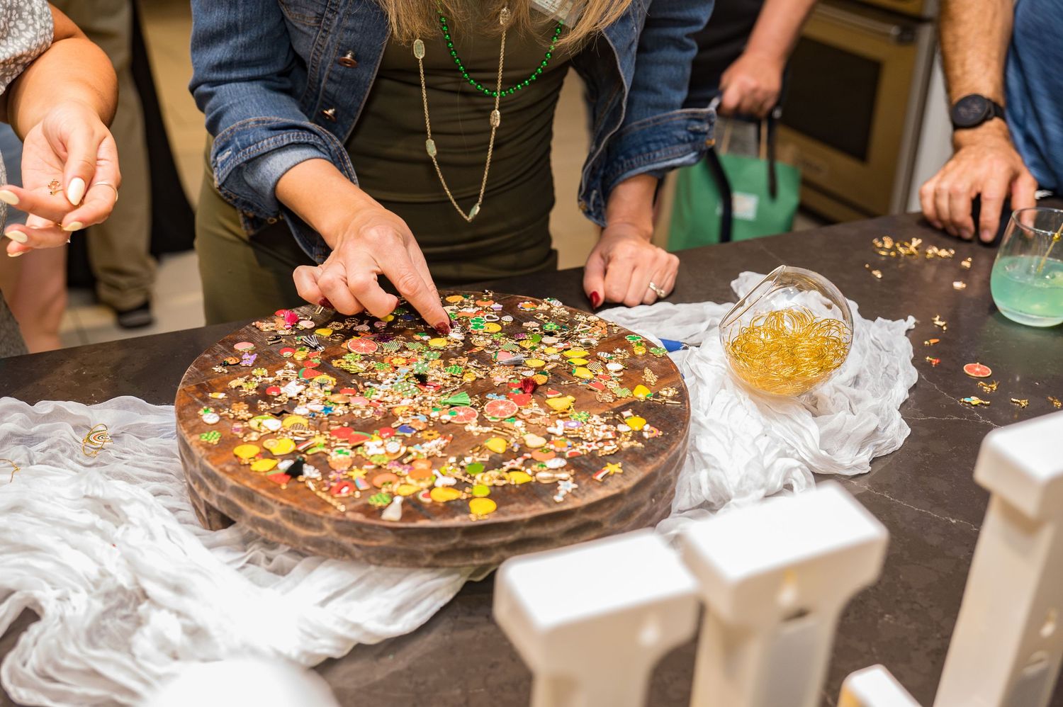 Guests reaching for toppings on a large decorated chocolate pizza at a St. Patricks Day event.