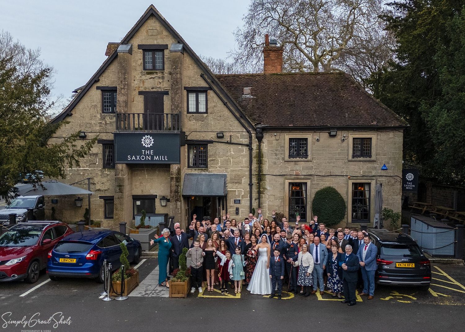 Wedding group photo of Jack, Stacey and all guests outside The Saxon Mill, Warwickshire, on Valentine's Day 2026.