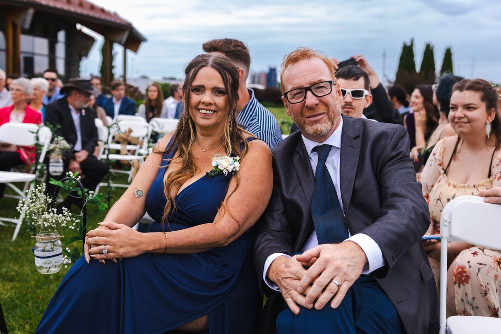 Wedding guests celebrating and dancing together at an outdoor reception party with string lights overhead.