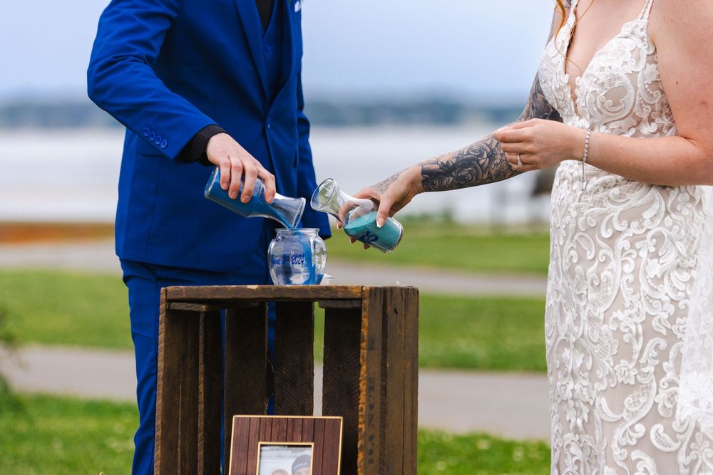 Wedding couple performing a unity ceremony with wooden boxes at outdoor venue.