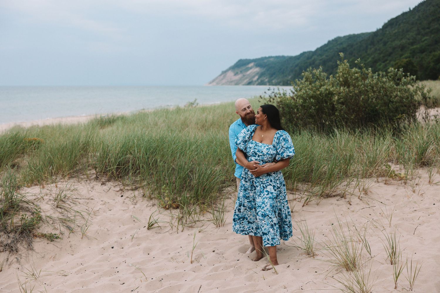 Couple posing for couples photoshoot on Lake Michigan beach in Traverse City, Michigan