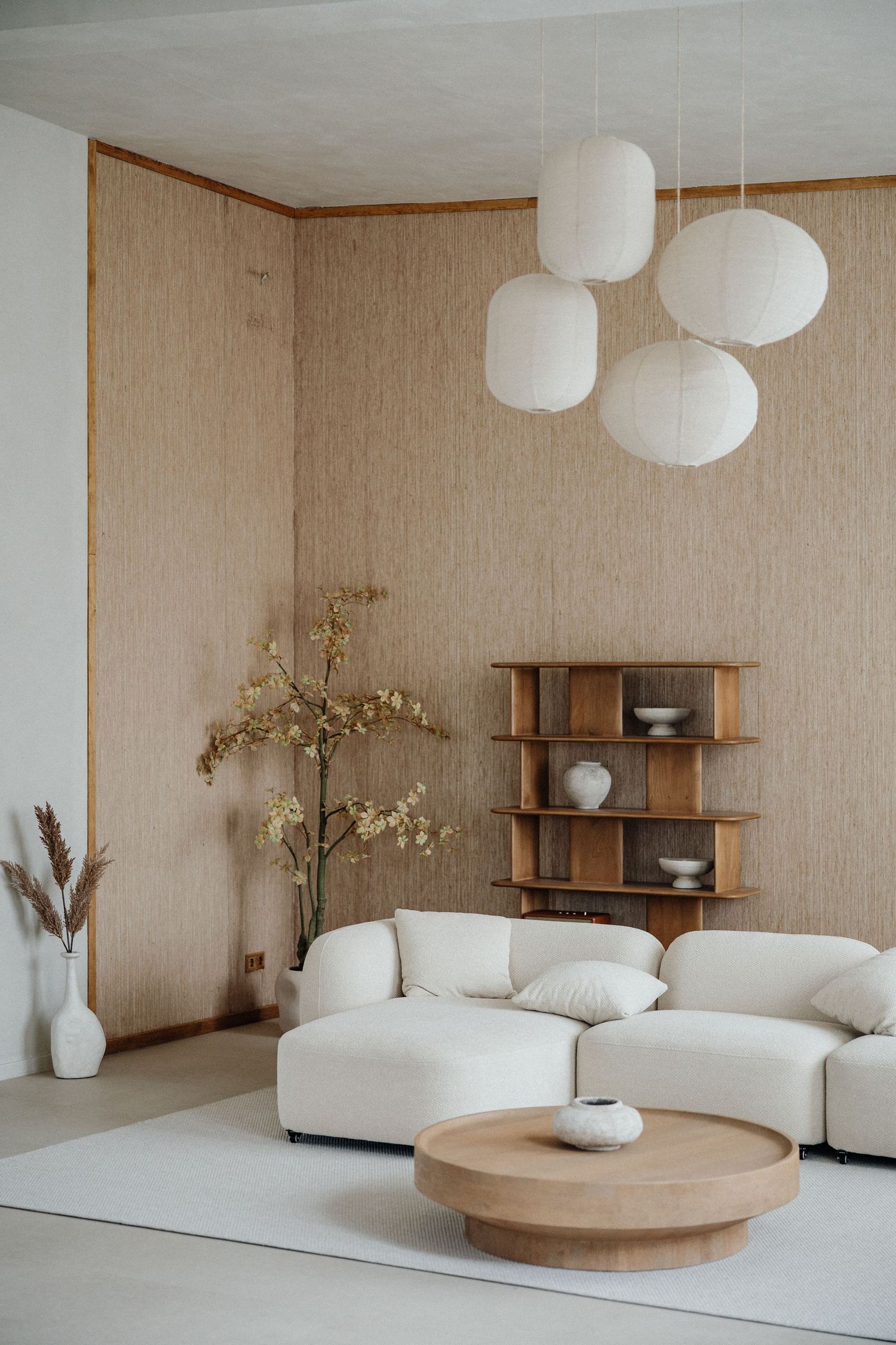 Minimalistisches Wohnzimmer mit weißem Sofa, Holzregalen und Papierlampen im japanischen Stil – Business Shooting Frankfurt