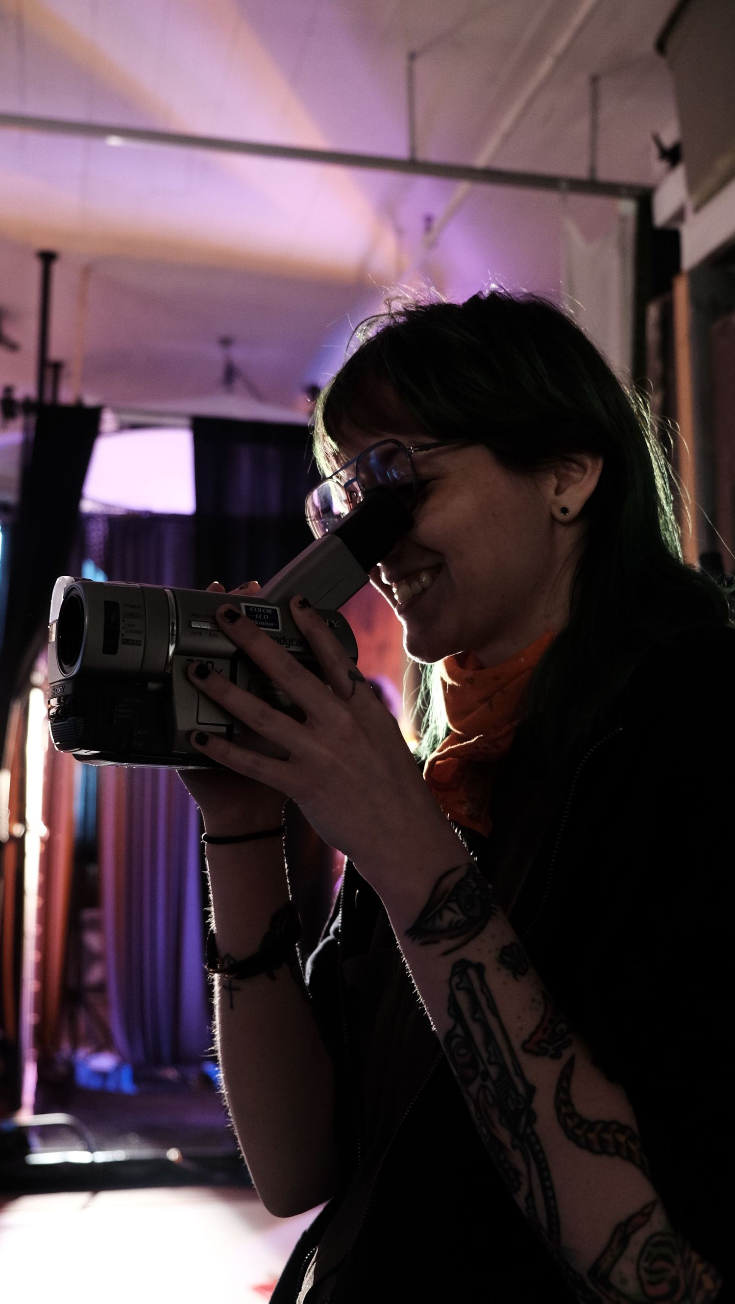 A sequence of silhouetted photographers taking pictures with cameras in a dimly lit indoor space.