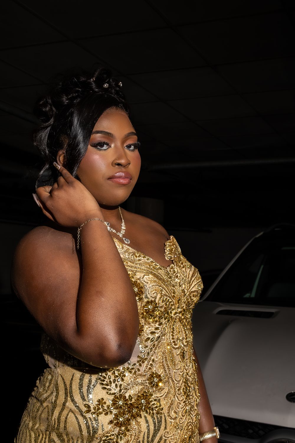 A person wearing a glamorous gold sequined dress poses against a dark background.