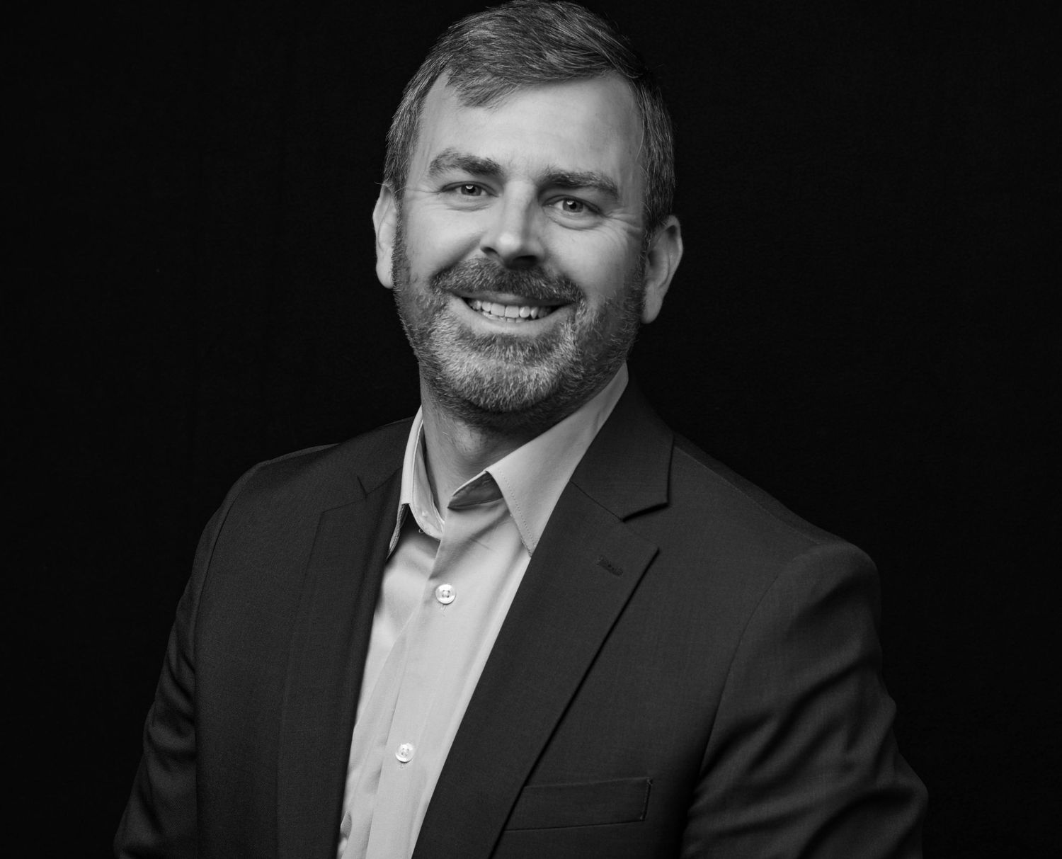 Black and white photo of Andrew Pustay smiling.
