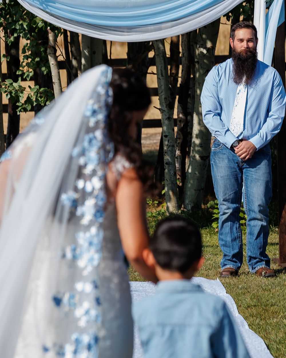 intimate outdoor Montana wedding, groom over bride shoulder first look at the alter