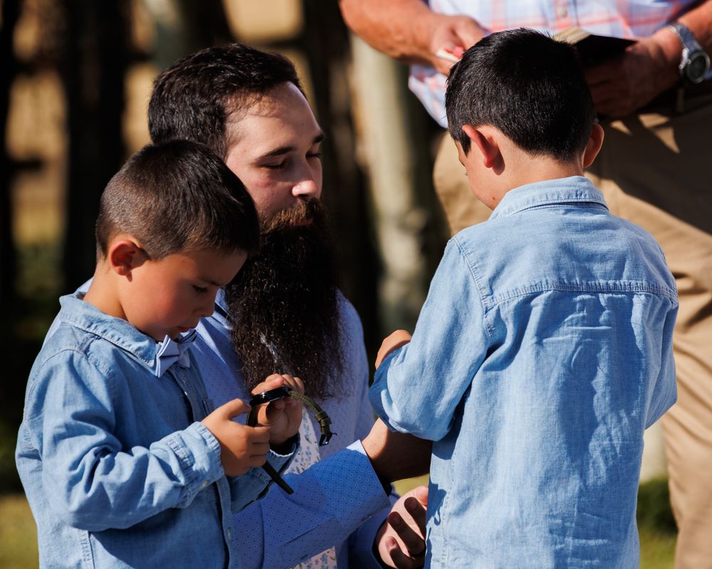 Brides son in blue inspecting his new watch