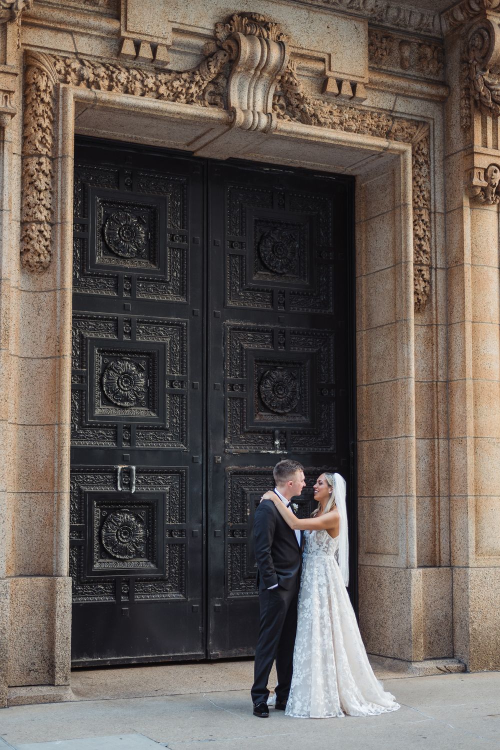 Wedding portraits taken in front of ornate carved stone doorways with decorative architectural details.