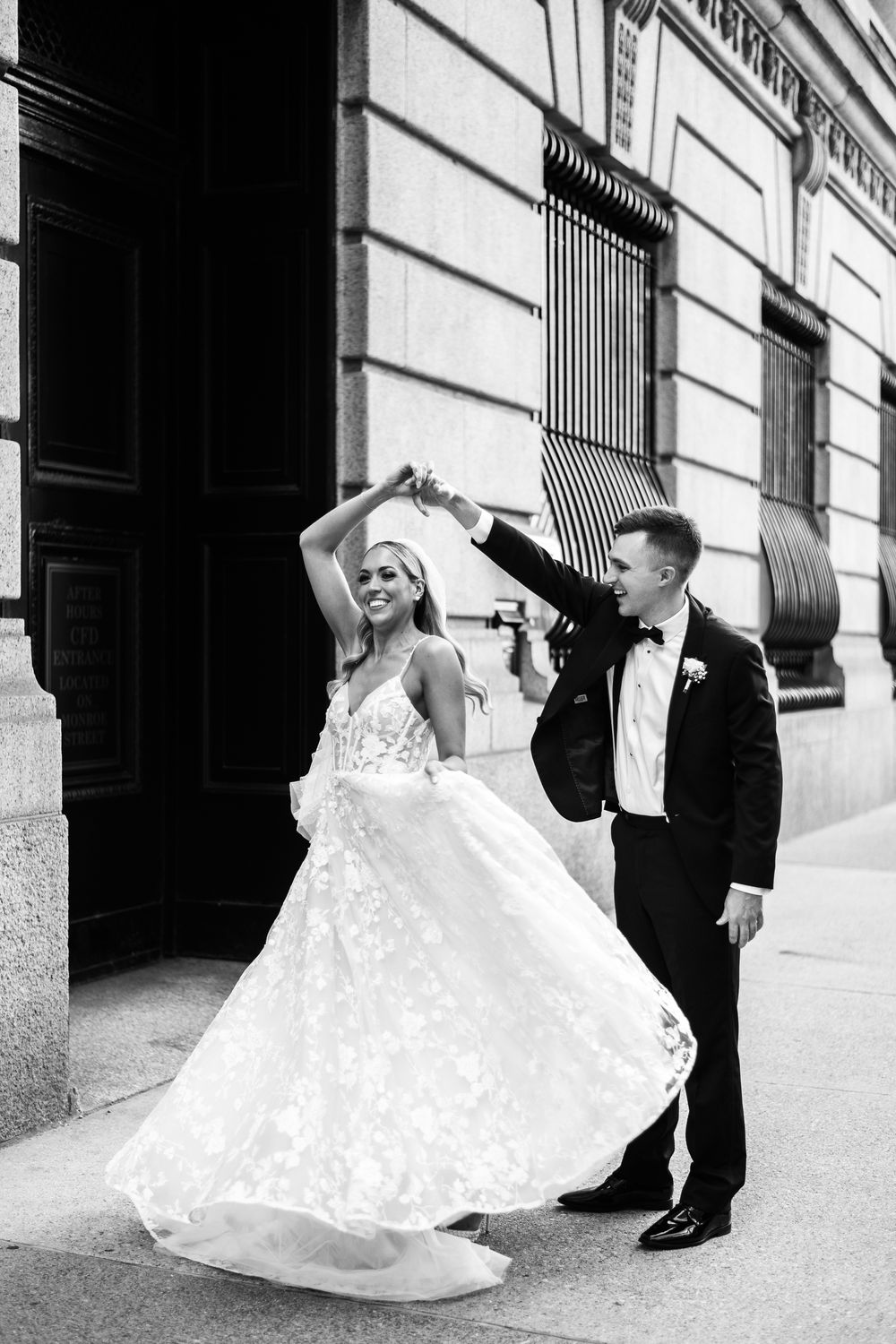 A romantic black and white wedding photo sequence showing a couple dancing and twirling on a city sidewalk.