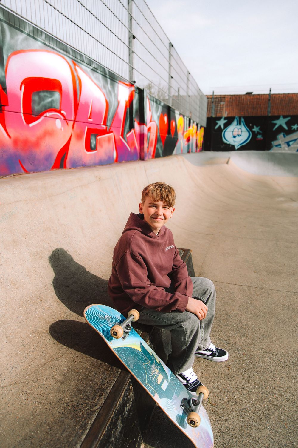 Jongen met skateboard tijdens een persoonlijke communieshoot.
