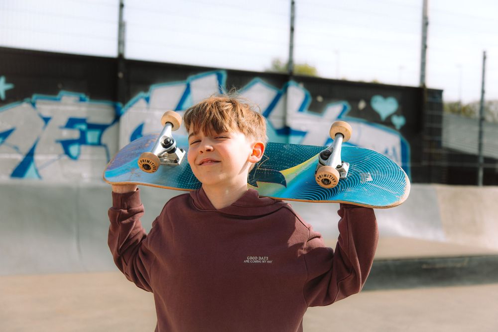 Jongen met skateboard tijdens een persoonlijke communieshoot.