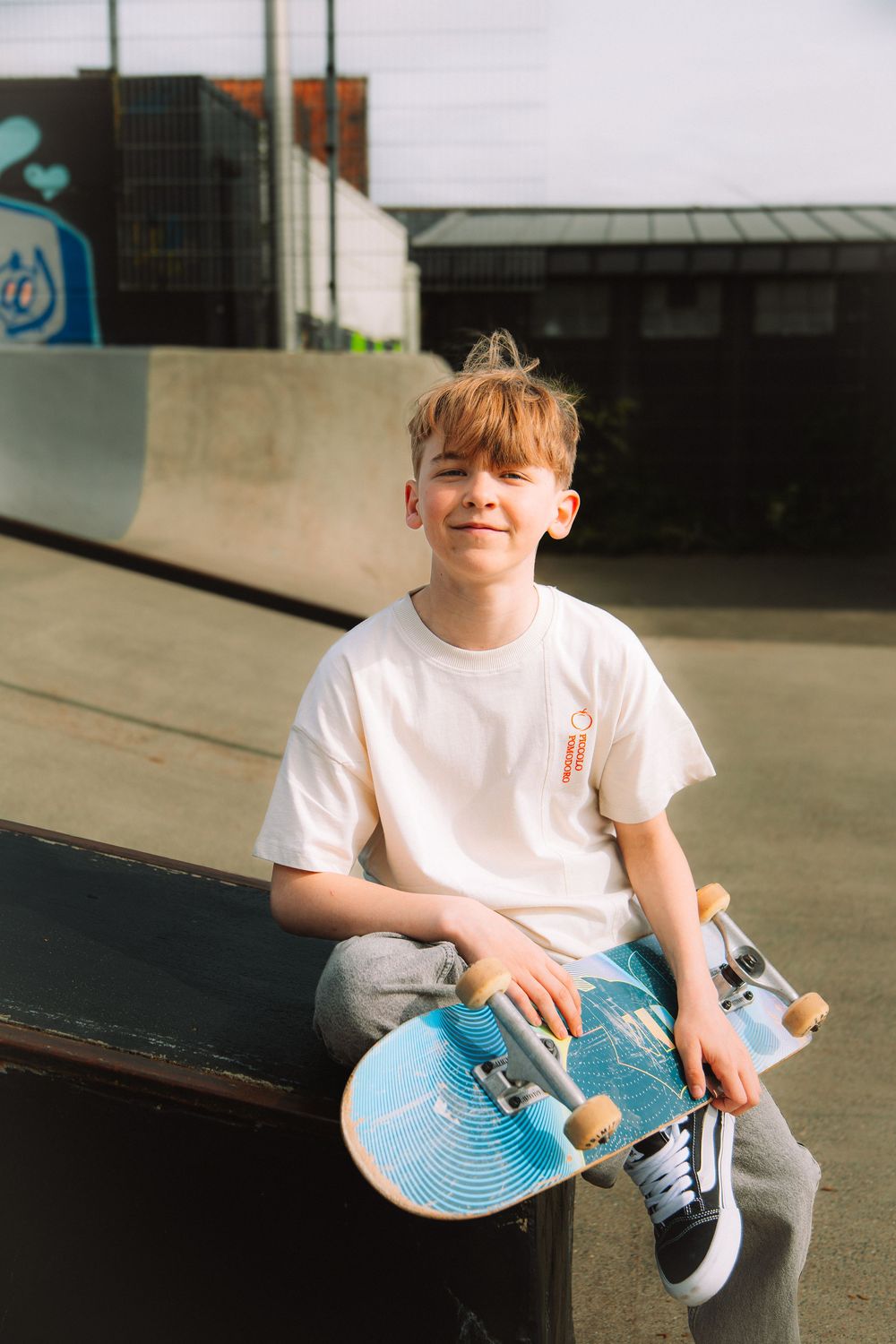 Jongen met skateboard tijdens een persoonlijke communieshoot.