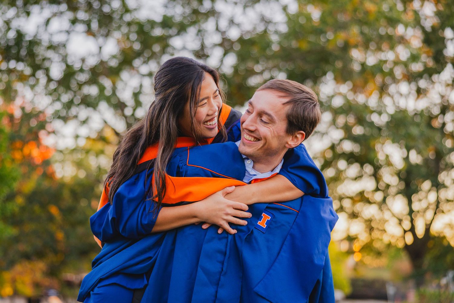 Cute couple laughing together with graduation gowns on at Japan House at UIUC
