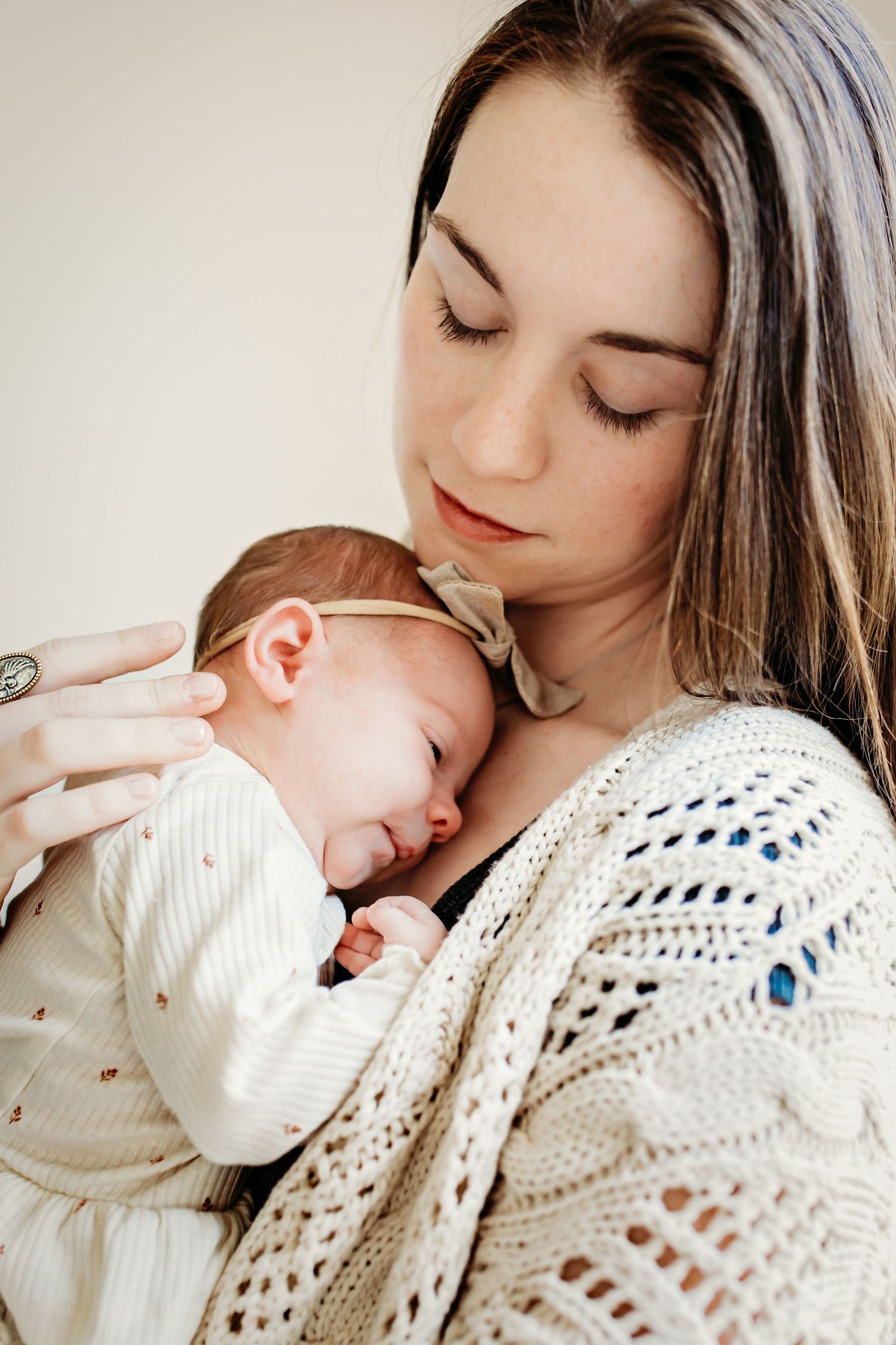 A tender moment between parent and baby in white, with a cozy knit blanket wrapped around them in Fort Worth, TX
