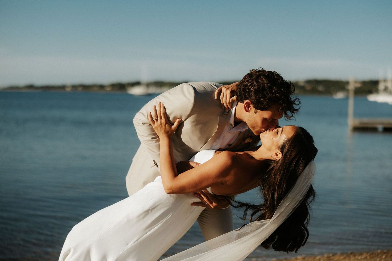 Groom dips and kisses bride on Montauk beach at The Crow's Nest wedding