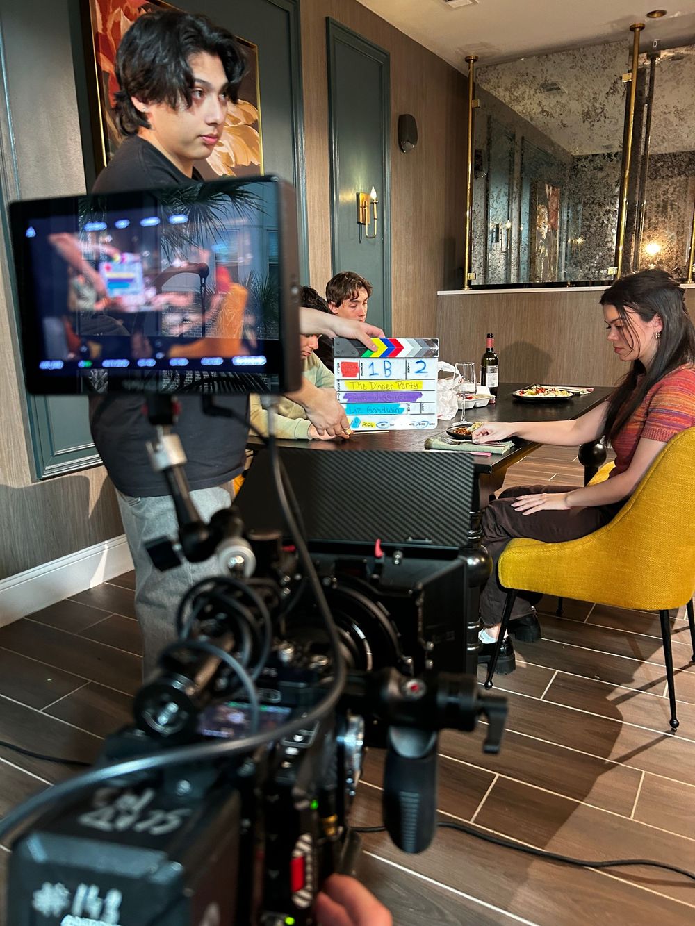 Behind-the-scenes video production setup showing camera equipment and lighting in a modern interior space.