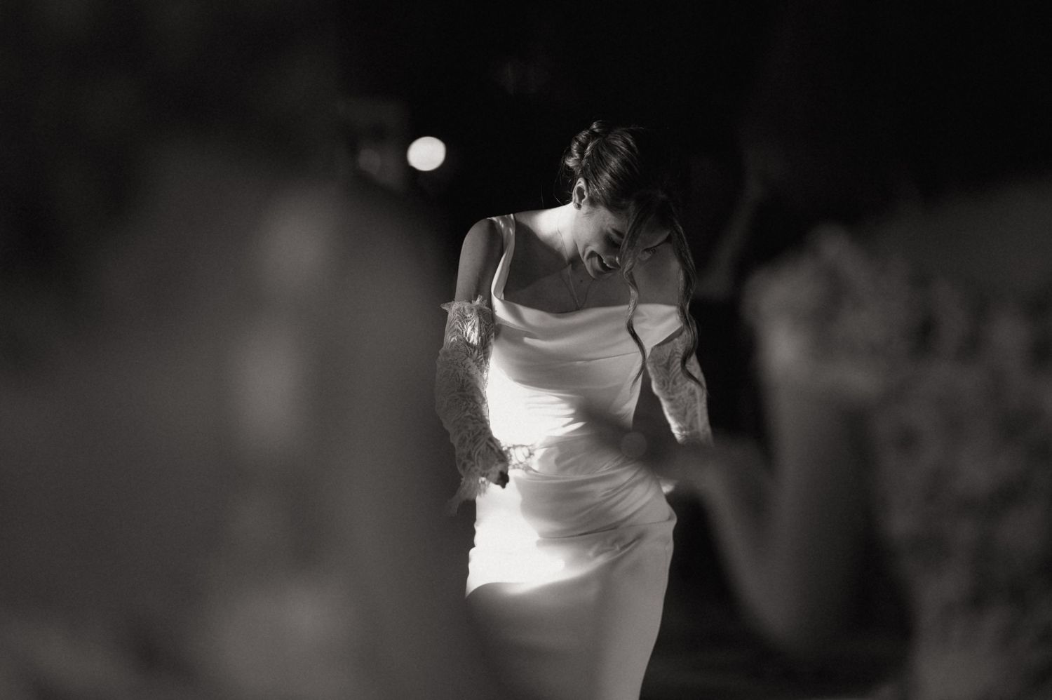 Black and white photo of a bride in a white gown dancing elegantly at a wedding reception.