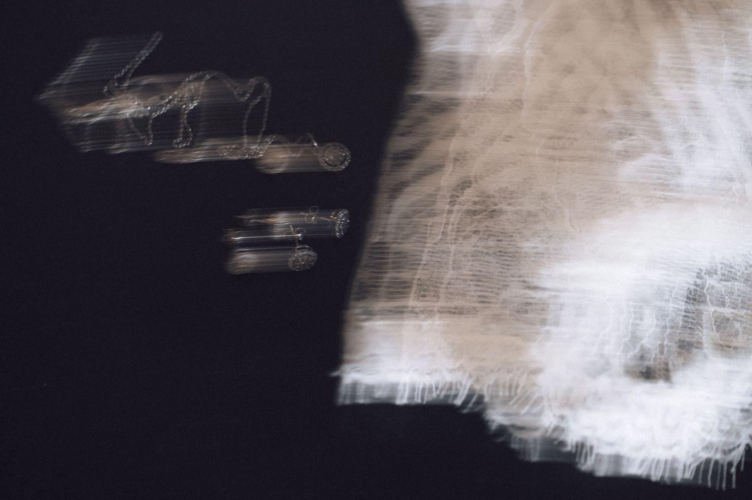 Abstract dark artistic photograph with blurred white light streaks and shadows creating a mysterious motion effect.