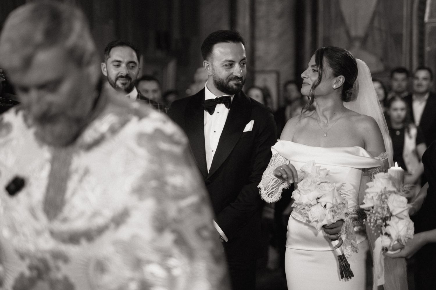 Bride and groom walk down the aisle in a church wedding ceremony, bride holding white bouquet.