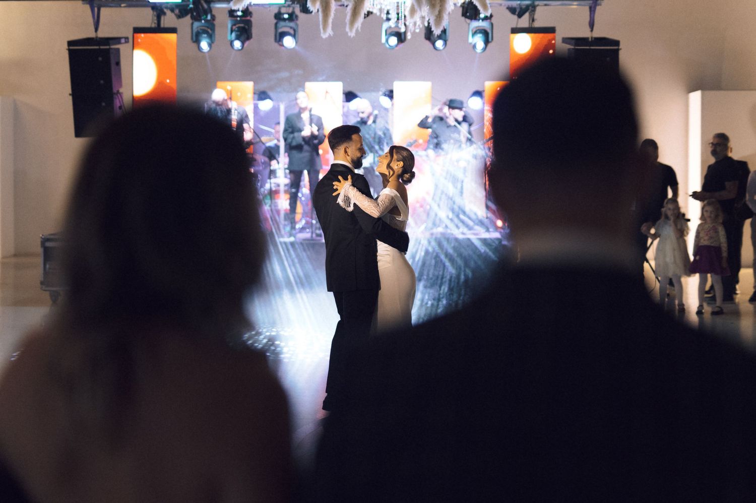 Couple sharing first dance at wedding reception with dramatic lighting and fog effects.