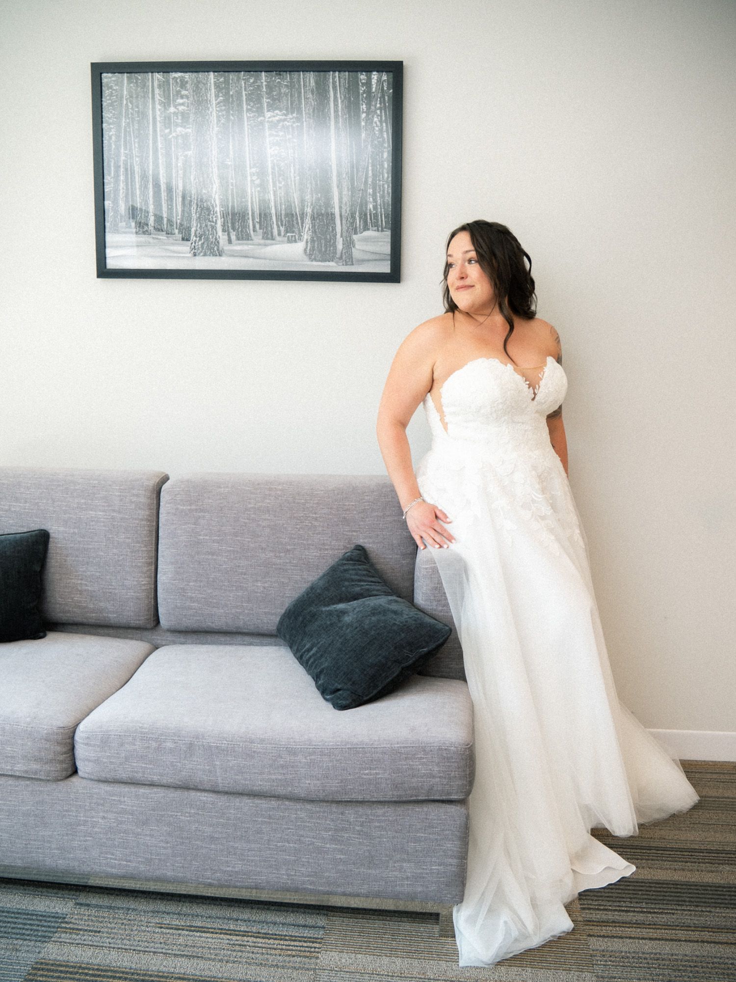 A series of photos showing someone in a white wedding dress posing elegantly on a modern gray couch against a white wall.