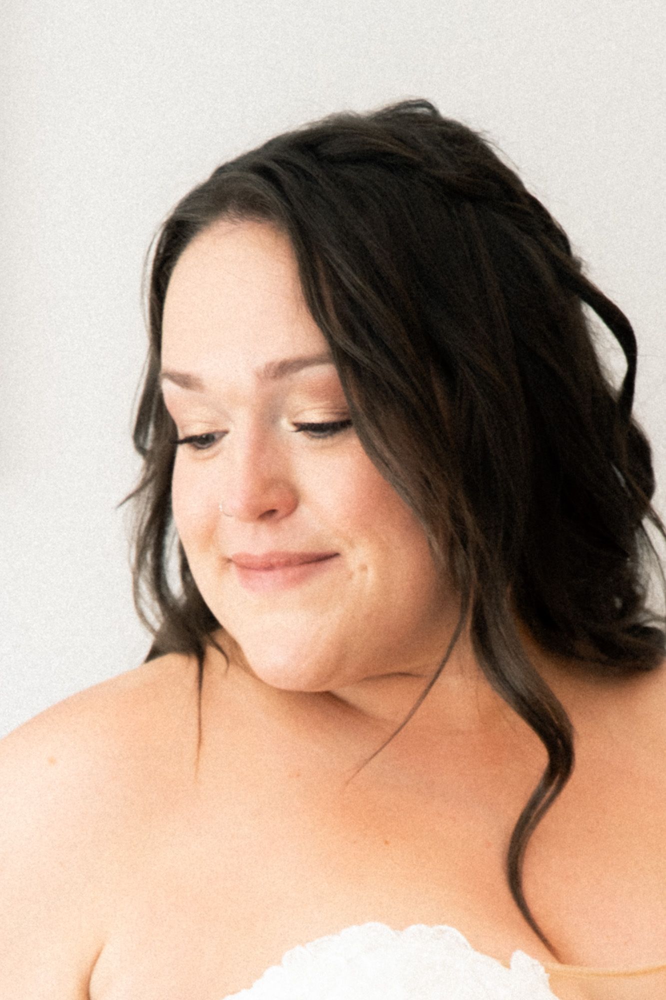 A series of four artistic portrait photos showing a dark-haired person with closed eyes and a gentle smile against white.