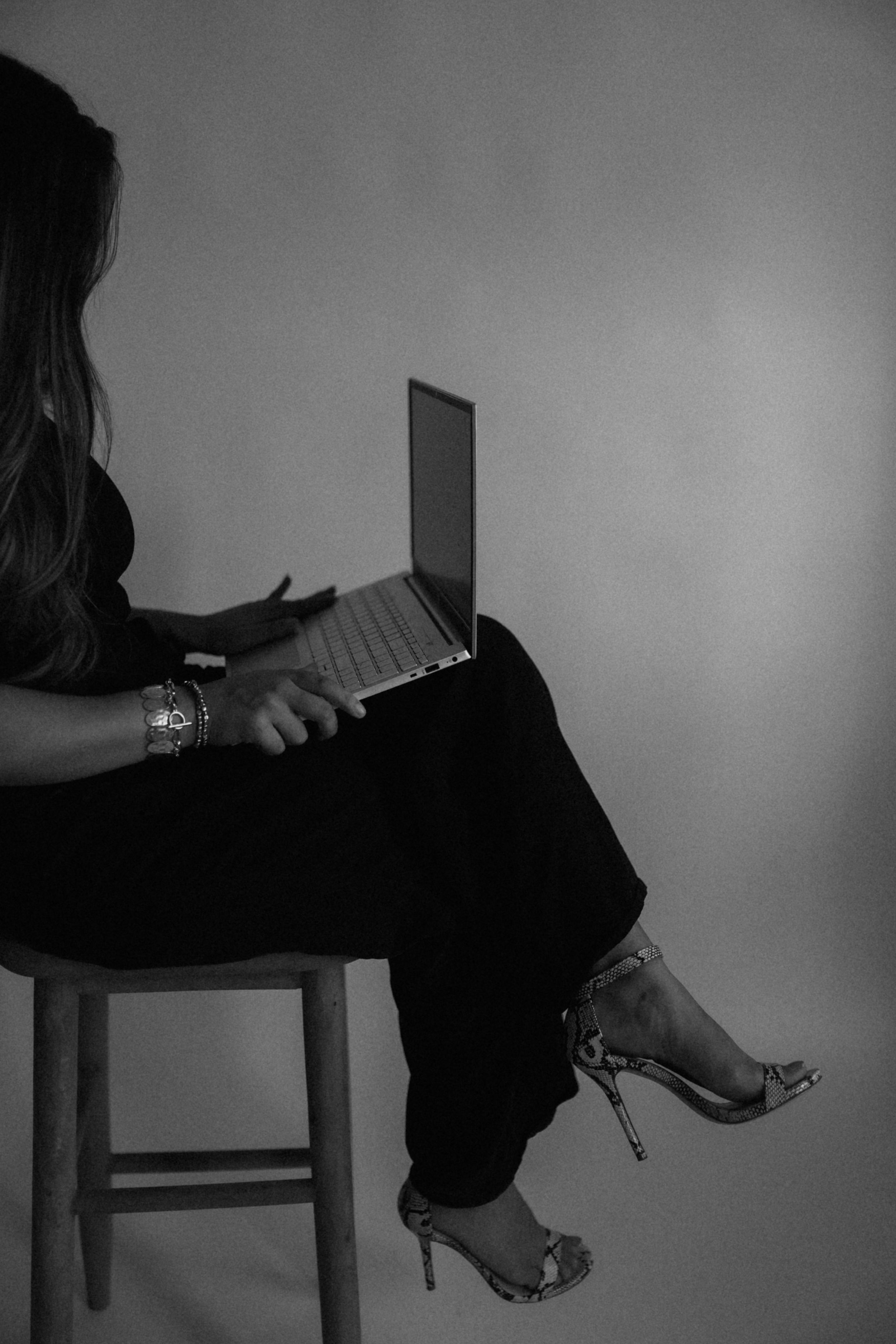Black and white sequence showing laptop usage in various positions while sitting in a chair.