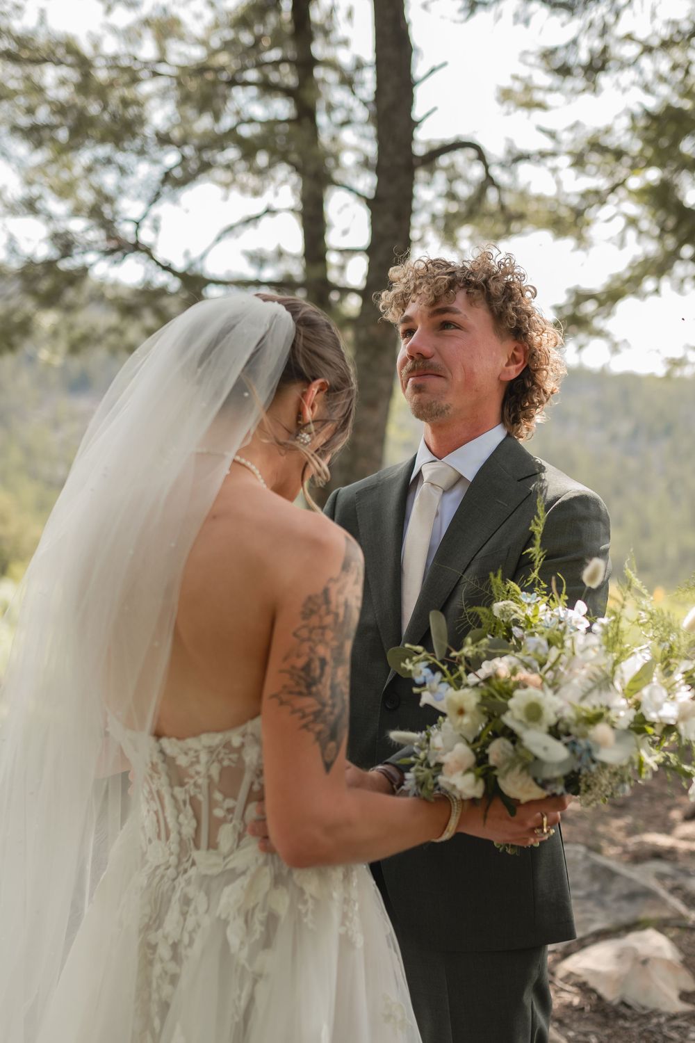 Bride and groom share intimate moments during their outdoor mountain wedding ceremony.