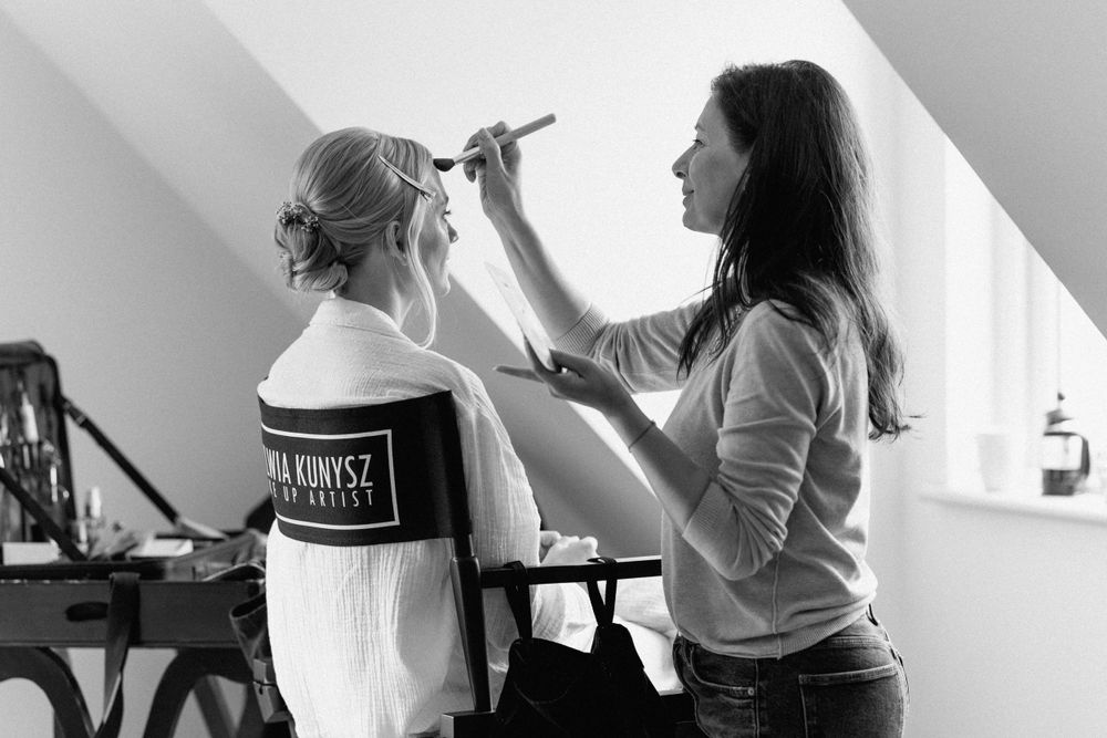 Black and white photo of wedding day makeup preparation.