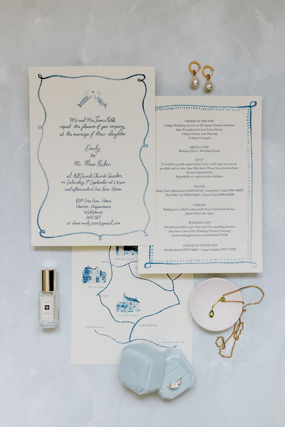 Wedding stationery flat lay with blue details and jewelry accessories.