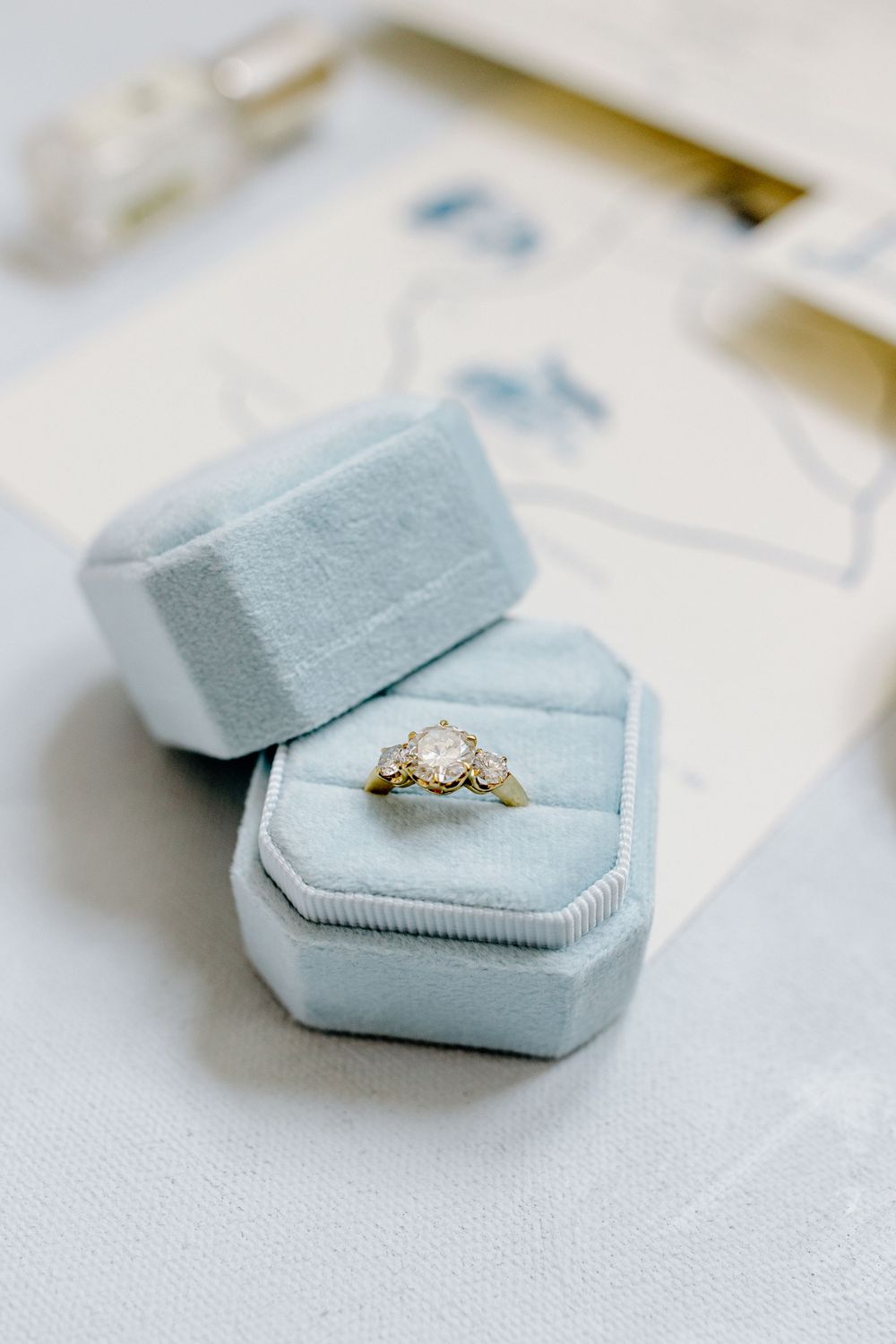 Elegant engagement ring in light blue velvet ring box.