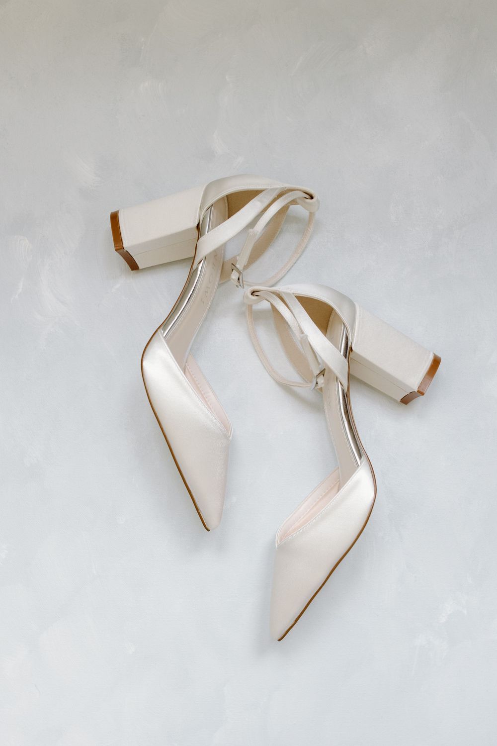 Elegant white block heel bridal shoes on light background.