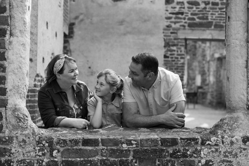 A candid black and white photograph of capturing a tender moment between a family during a relaxed summer family photography session.