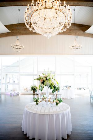 Elegant wedding reception table with crystal chandelier and white floral centerpiece.