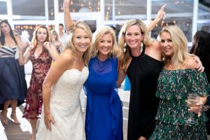 A wedding celebration with guests in elegant attire gathering for a group photo.