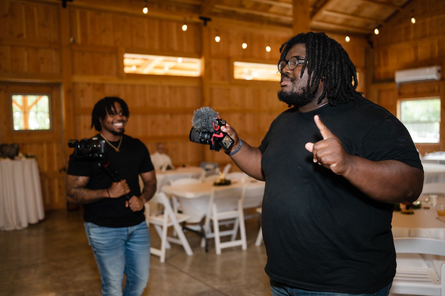 Candid moment of two people enjoying themselves at a rustic barn wedding reception.