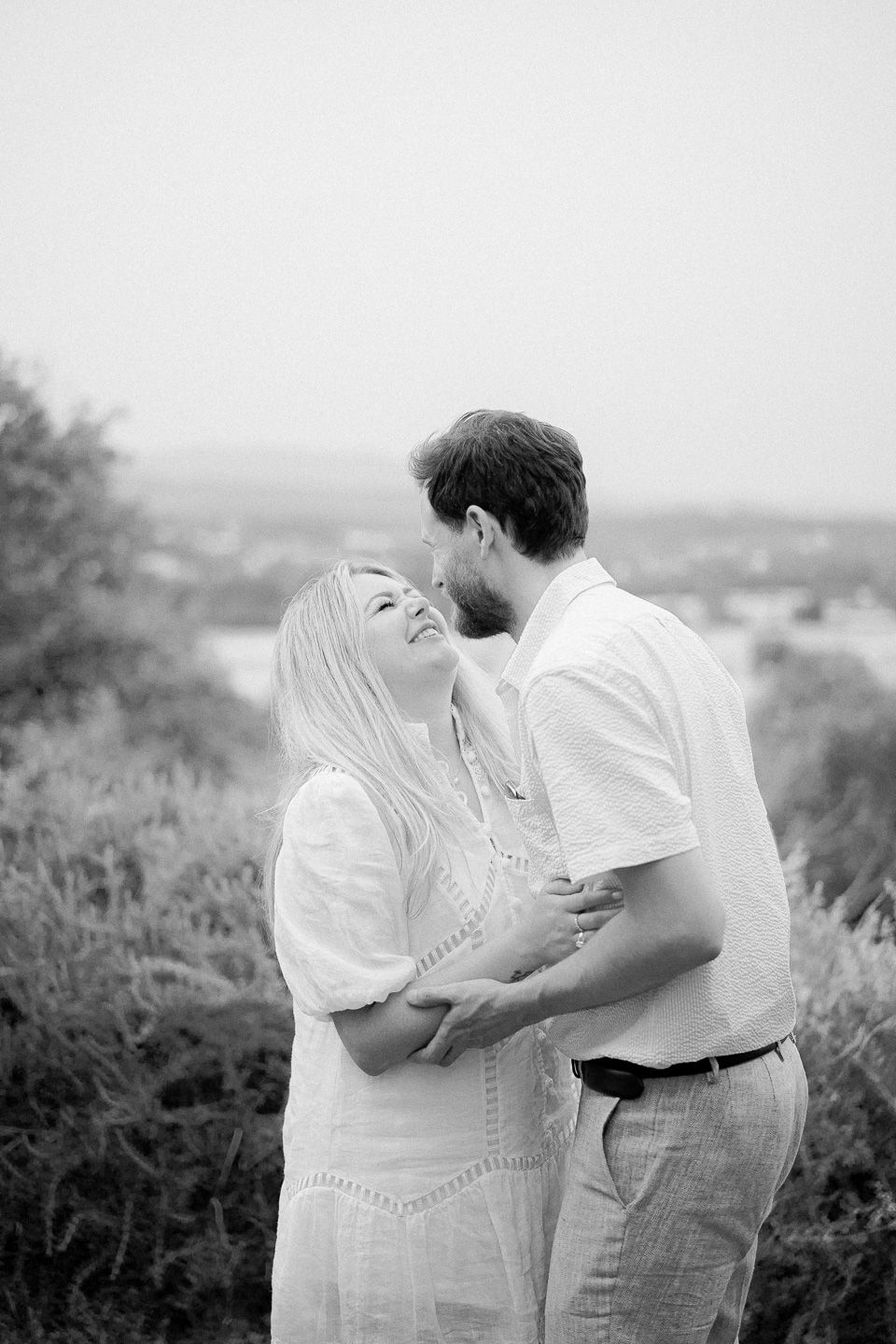 Couple laughing at each other lovingly during an engagement photography session in the Tuscan countryside
